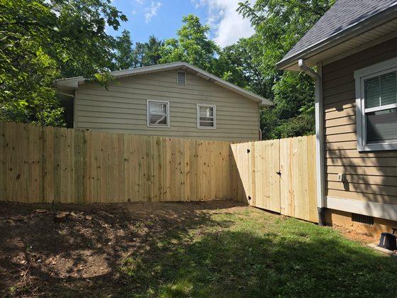 Privacy fence and gate running between two houses