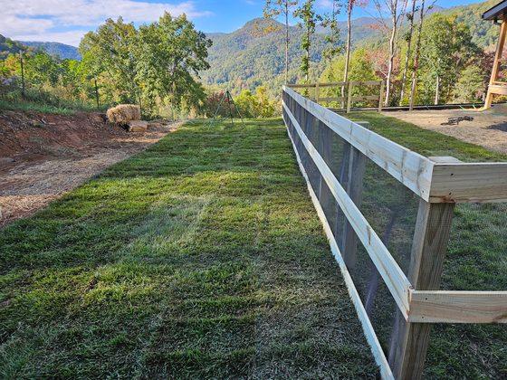 Rail-and-mesh fence following the grade