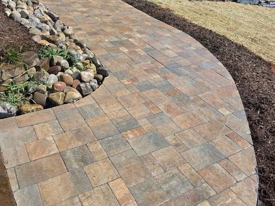 Curved paver walk with river rock border